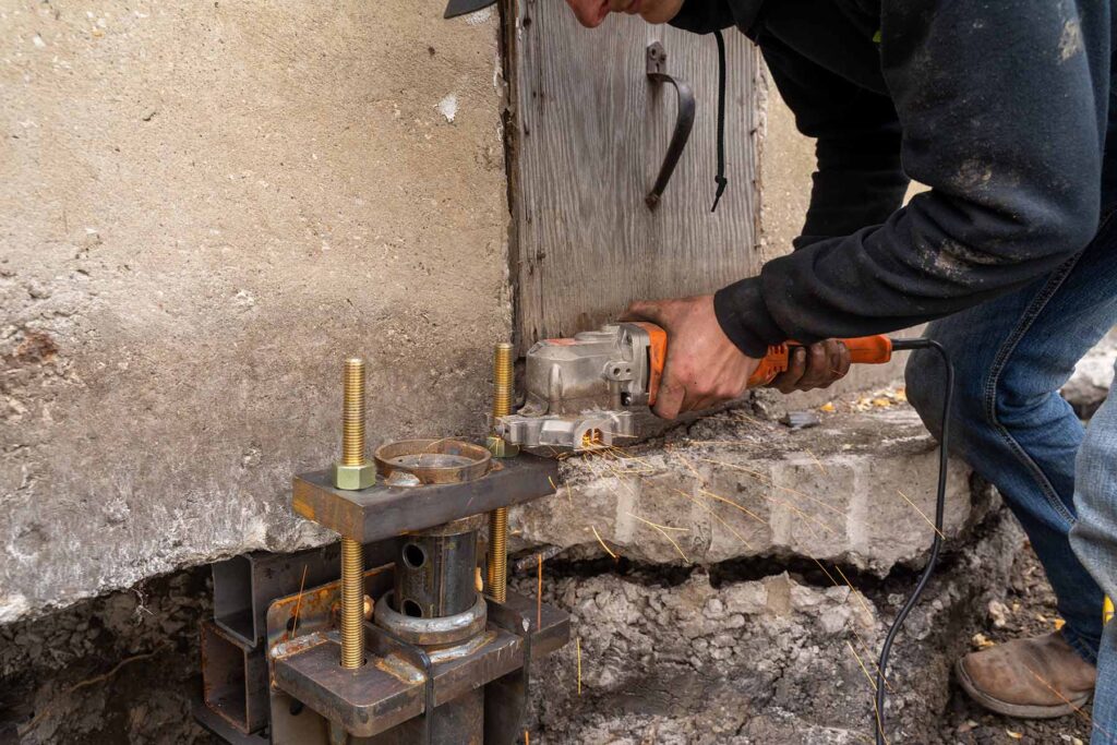 Man working on foundation repair device