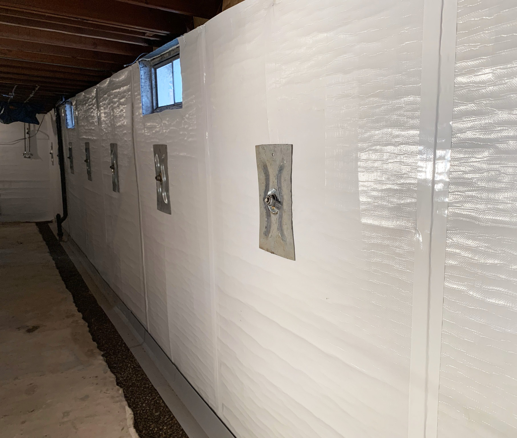Wall anchors on a waterproofed wall