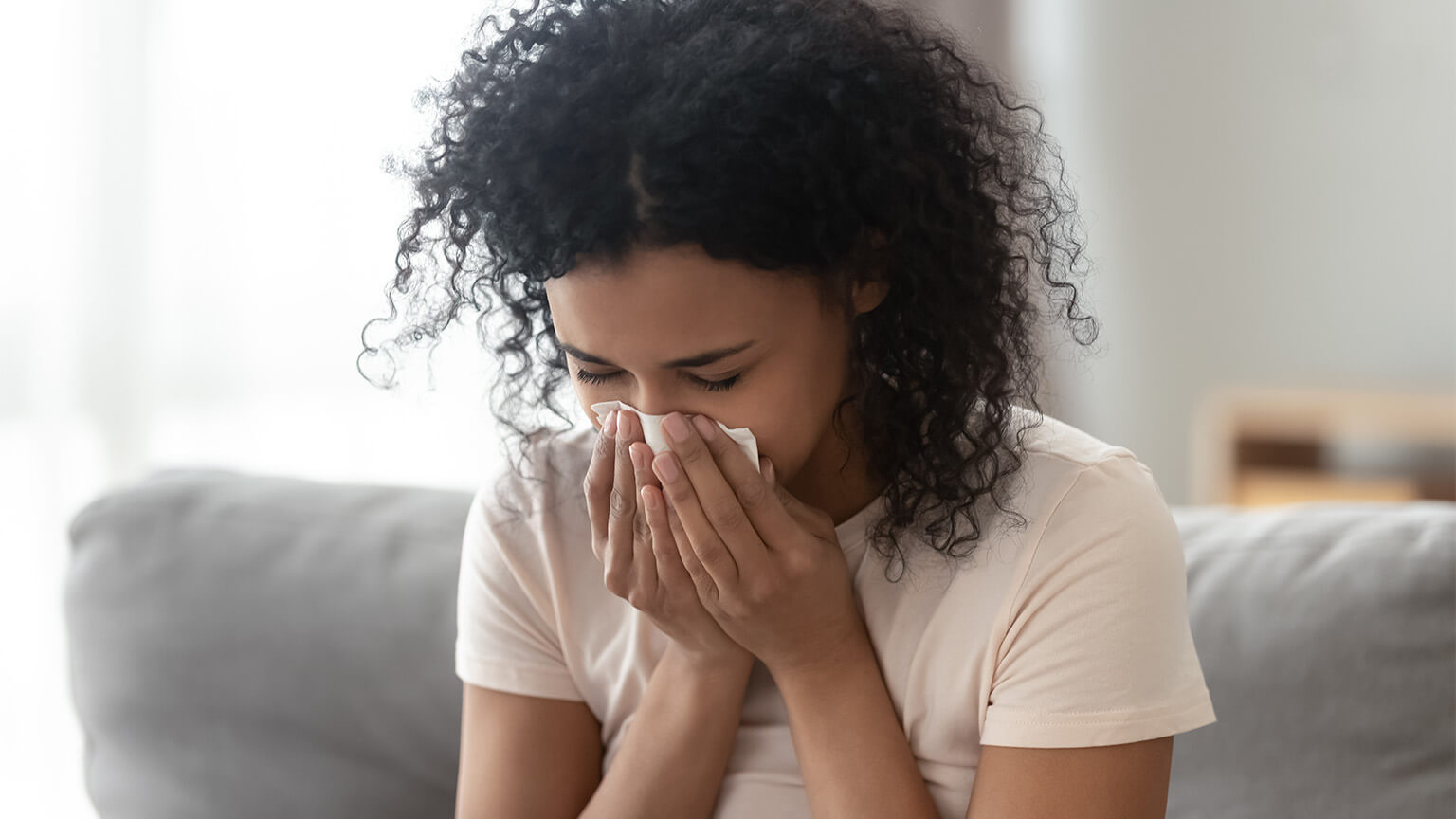 A woman suffering from allergy symptoms