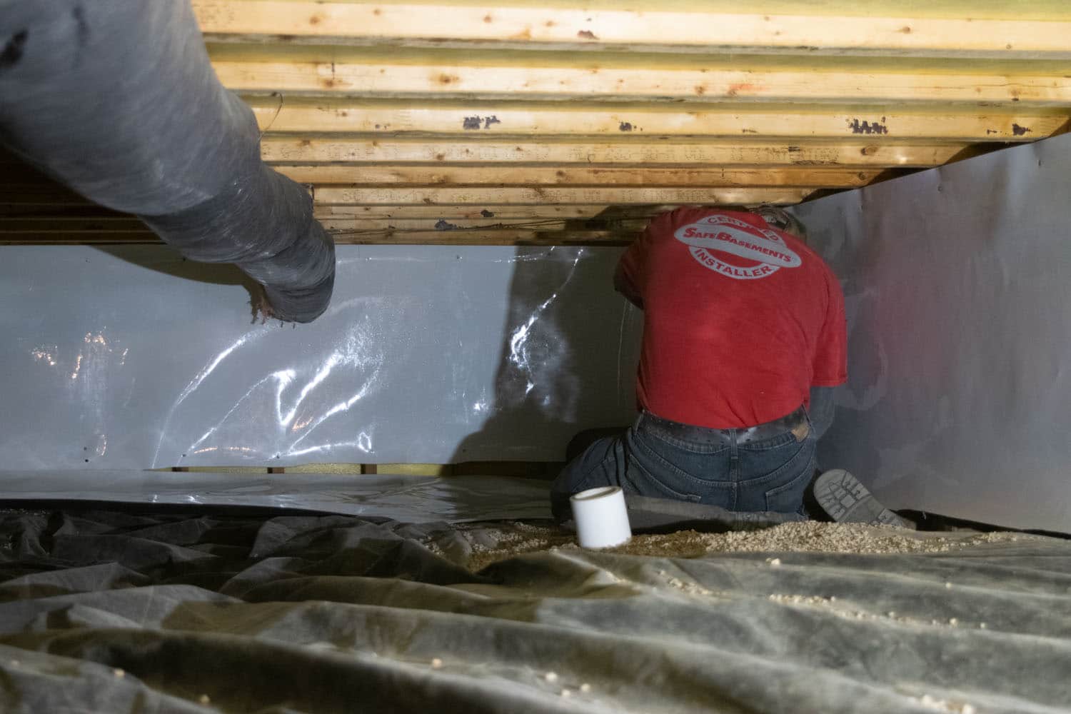 man working crawl space underneath home